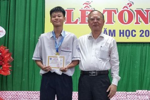 穗城会馆理事长卢耀南向九年级学生刘温振明夺得国际篮球赛金奖赠送奖项。