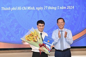 市人委会主席潘文迈（右）向郭玉俊同志颁授委任《决定》。（图：越勇）