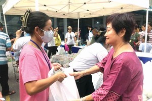 平西市场华人商贩应氏莲向病童家属赠送礼物。