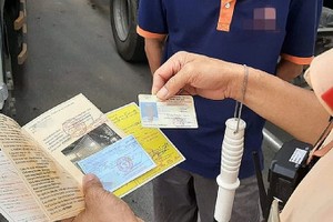 交警在核对驾照及相关文件。（示意图：互联网）