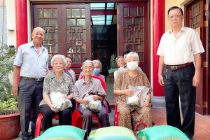 二府会馆副理事长谢忠成（前排右一）理事王奕谋（左一）向高龄乡亲赠送端午节礼物。