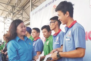 第五郡劳动联团主席黎氏碧幸向劳工赠送感谢礼物。