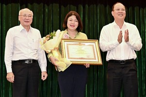 市委常务副书记、市委第35号指委会主任阮胡海（右一）和市委宣教处主任、市委第35号指委会副主任潘阮如奎（左一）向富润郡颁发奖状。（图：越勇）