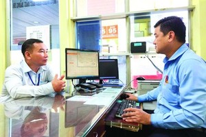 客户向第十郡Saigon Petro加油站职工提供个人资讯申报电子发票。（图：黄雄）