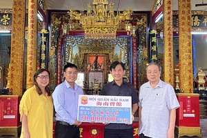 海南会馆理事长林明辉（右二）、常值副理事长孙盛强、理事曾碧把赞助赠报经费移交给本报编委文忠孝。