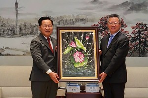 黄松主席（左）和陈杰副市长互赠纪念品。