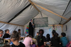 一名教师在临时搭建的教室内为学生授课。（图：互联网）