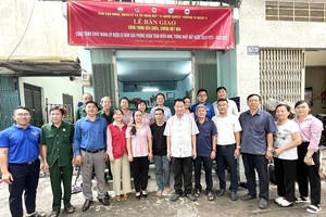 庆云南院住持周华邦与郡、坊领导向贫困户移交“温情屋”工程。