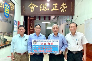 崇正会馆理事长郑鑫发（右二）；常值副理事长黄木锦（右一）和副理事长兼财政赖振伦（左一）把2000万元较交给本报编委文忠孝。