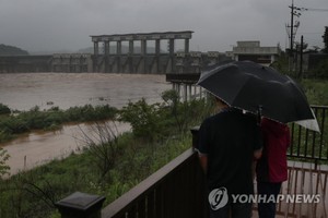 6月28日，在位于京畿道涟川郡的郡南大坝，居民观看水坝开闸泄洪。朝鲜梅雨季暴雨不断，导致临津江下游的韩国京畿道最北端必胜桥水位上涨。（图：韩联社）