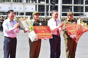 国家主席苏林与市人委会主席潘文迈向基层保安力量赠送礼物。（图：越通社）