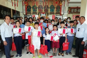 理事长方南(左)和监事长方炳星(右)与颁奖学生们合照。