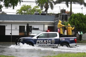 7月5日，在墨西哥东南部金塔纳罗奥州坎昆，警车驶过积水的道路。（图：新华社）
