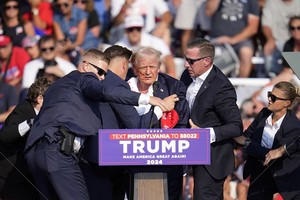 特朗普在特勤人员保护下撤离演讲台。（图：互联网）