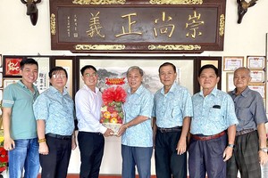 本报编委文忠孝（左三）向崇正会馆理事们赠送水果篮祝贺观音诞。