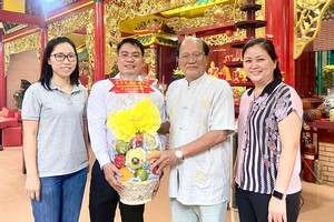 文忠孝编委（左二）向温陵会馆理事长洪世真（右二）赠送果篮敬奉观音娘娘。