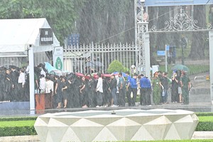 人群冒着大雨排队登记进入统一会场吊唁阮富仲总书记。