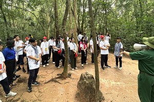 夏令营青少年游览并探索古芝县地道。（图：吴平）