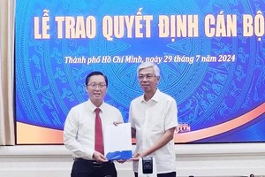 阮俊财同志（左）从市人委会副主席武文欢手中接过人事委任《决定》。（图：东山）