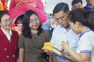 市人委会副主席阮文勇(右二)参观平抑市场流动售货活动。