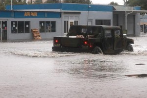 当地时间5日在佛罗里达州锡达礁，一辆国民警卫队车辆驶过一条由被洪水淹没的街道。（图：AFP）