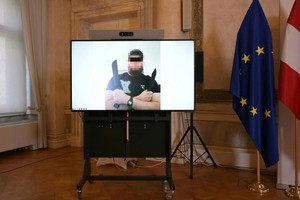 屏幕上显示一名男子的照片，该男子因涉嫌策划恐怖袭击而被捕，该袭击导致美国超级巨星泰勒·斯威夫特的维也纳巡回演唱会被取消。（图：AFP）