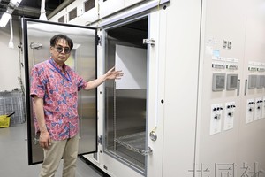 图为8月1日，日本农业和食品产业技术综合研究机构的米丸淳一介绍人工气象室。（图：共同社）