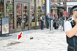 当地警方封锁发生持刀伤人案现场，左方地上留有案发遗下痕迹（箭嘴示）。（图：Getty Images）