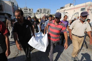 在加沙地带南部城市汗尤尼斯的纳赛尔医院，人们搬运以军袭击遇难者的遗体。（图：互联网）