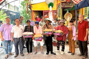 富山五行庙慈善组组长邹国荣（左二）与诸位热心人士向贫困者派发盂兰节礼物。