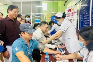 医护人员在给前来筛查的当地居民测量血压。（图：越通社）