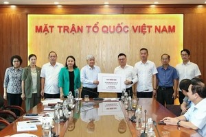越南祖国阵线中央委员会主席杜文战接收《人民报》代表移交的捐款。（图：Q.V）