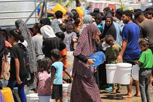 在加沙代尔巴拉赫，人们从儿基会支持设立的设施取水。（图：联合国）