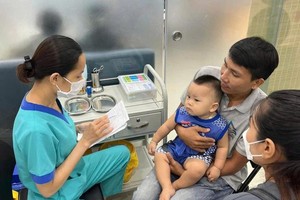 家长带孩子到FPT隆洲疫苗接种中心（第八郡）接种麻疹疫苗。（图：成山）