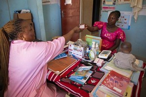 布基纳法索 Ziniaré 卫生中心的卫生工作者向孕妇赠送一盒 MMS 药片。（图：UNICEF）