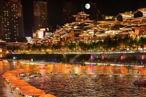 9月17日晚，游客在湖北省宣恩县城贡水河中乘坐竹筏赏夜景。（图：新华社）