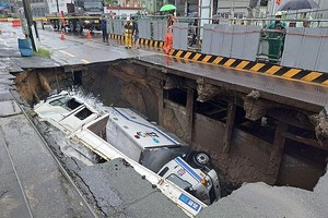 釜山沙上区某道路发生大型地陷，2辆卡车坠入坑中。（图：互联网）