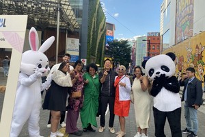 首尔特别市市长吴世勋(居中)和外国游客合影。（图：韩联社）