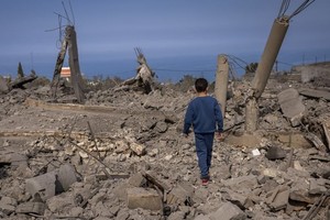 黎巴嫩南部，一名5岁的男孩走过被摧毁的建筑。（图：联合国）
