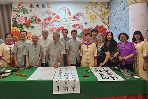 书法会会员互相交流书法。