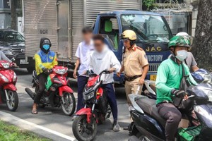 学生骑电动摩托车不戴安全帽被交警截停。（图：志石）