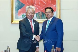 越南政府总理范明政（右）与亚洲基础设施投资银行（AIIB）行长金立群。（图：越通社）