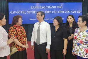 市越南祖国阵线委员会主席阮福禄（左三）同模范妇女交谈。