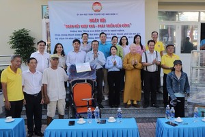 第十一郡领导和嘉宾与获赠送谋生工具的贫困者合影。