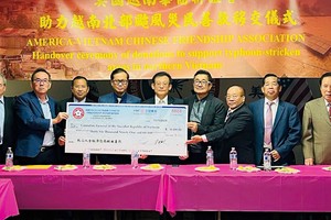 越南驻美国三藩市总领事馆总领事黄英俊（左四）接受旅美越南华人代表移交的赈灾捐款大支票。