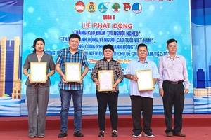 第六郡越南祖国阵线委员会主席丁黄忠向赞助商颁发感谢状。