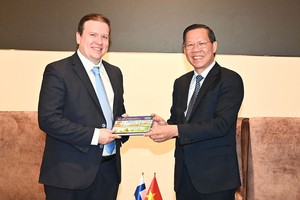 市人委会主席潘文迈（右）向芬兰对外贸易与发展部长维尔·塔维欧赠送纪念品。（图：越勇）