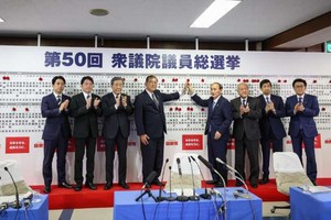 10月27日，在日本东京自民党总部，日本首相、自民党总裁石破茂（左四）和其他自民党成员一同将象征成功当选的红花贴在候选人名字上。（图：互联网）