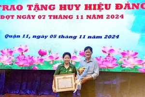 荣获55 年党龄纪念章的阮氏秋大娘和丈夫何永忠合影。