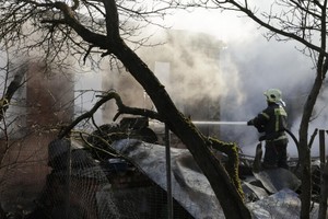 2024年11月10日，在莫斯科州斯塔诺沃耶村，一名救援人员正在扑灭无人机袭击后房屋大火。（图：AFP） 